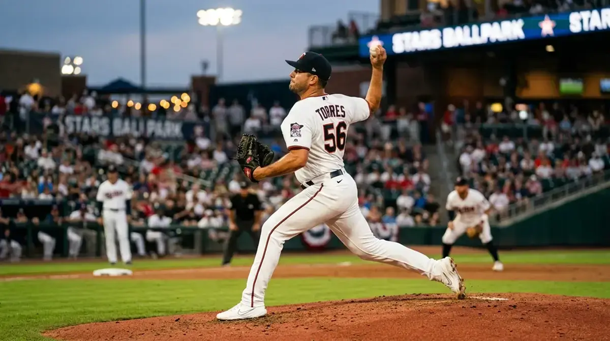 Relief pitcher warming up in an MLB bullpen with the outfield and stadium lights visible